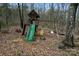 Wooded playground with a wood playset featuring a green slide and two swings for outdoor fun at 946 Laurelwood Dr, Clover, SC 29710