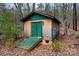 Wood shed with green door, wood ramp and green trim surrounded by trees and foliage at 946 Laurelwood Dr, Clover, SC 29710