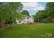 Expansive backyard features a lush lawn, mature trees, and a wooden deck perfect for outdoor living at 1006 Baldwin Ln, Waxhaw, NC 28173
