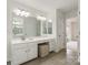 Bright bathroom featuring double sinks, a vanity, a large mirror, and wood-look tile flooring at 1006 Baldwin Ln, Waxhaw, NC 28173