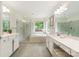 Bright bathroom with double sinks, shower with glass door, and soaking tub underneath large window at 1006 Baldwin Ln, Waxhaw, NC 28173