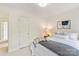 Neutral bedroom featuring a comfortable queen bed, soft lighting, and a door to another room at 1006 Baldwin Ln, Waxhaw, NC 28173