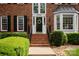 Close-up of the brick front of the home, showing the front door, landscaping, and windows at 1006 Baldwin Ln, Waxhaw, NC 28173