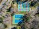 Aerial view of tennis courts surrounded by green trees, with four blue and red courts at 1008 Southwest Dr # 8, Davidson, NC 28036