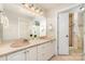 Bathroom with double sinks, granite countertops, walk-in shower, and large mirror with decorative lighting at 1008 Southwest Dr # 8, Davidson, NC 28036