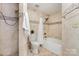 Well-lit bathroom featuring tile surround tub/shower, decorative accent tile, and a modern toilet at 1008 Southwest Dr # 8, Davidson, NC 28036