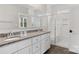 Modern bathroom features a dual sink vanity, granite countertops, sleek white cabinetry and a glass-enclosed shower at 108 Glencoe Ln # 105, Mooresville, NC 28117