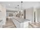 Bright open kitchen with white cabinets, granite countertops, an oversized island, pendant lighting and stainless appliances at 108 Glencoe Ln # 105, Mooresville, NC 28117