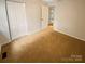 This bedroom features neutral walls, carpet and a closet with bifold doors at 10905 Park Rd, Charlotte, NC 28226