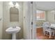 Half bathroom leading to a kitchen and dining area with wood floors and an open floor plan at 11013 Dundarrach Ln, Charlotte, NC 28277