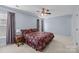 Spacious bedroom features a ceiling fan, carpet flooring and large windows with curtains at 11013 Dundarrach Ln, Charlotte, NC 28277