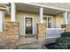 Welcoming front porch with stone pillars, a decorative wreath, and a cozy entrance at 11013 Dundarrach Ln, Charlotte, NC 28277