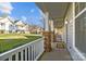 Relaxing front porch view with white railings, stone pillars, and a view of the lawn at 11013 Dundarrach Ln, Charlotte, NC 28277