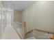 Hallway with carpet floor, wooden railings, and white doors leading to other rooms at 11013 Dundarrach Ln, Charlotte, NC 28277