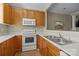 Well-lit kitchen featuring wooden cabinets, white appliances and countertops, and a stainless steel sink at 11013 Dundarrach Ln, Charlotte, NC 28277