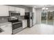 Well-lit kitchen featuring stainless steel appliances and a view to the backyard through sliding glass doors at 13413 Glasgow Green Ln, Charlotte, NC 28213