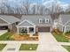 Inviting home featuring a covered porch, two-car garage, and manicured lawn at 15103 Honeycutt Dr, Huntersville, NC 28078