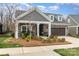 Charming home with stone accents, covered porch, and well-maintained landscaping at 15103 Honeycutt Dr, Huntersville, NC 28078