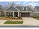 Charming single-story home featuring stone and gray siding, well-manicured landscaping, and a two-car garage at 15103 Honeycutt Dr, Huntersville, NC 28078