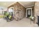 Inviting front porch with rocking chairs, brick facade, and decorative floral arrangements flanking the black front door at 15103 Honeycutt Dr, Huntersville, NC 28078
