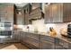 Close-up of the kitchen featuring stainless steel appliances, dark cabinetry, and granite countertops with stylish backsplash at 15103 Honeycutt Dr, Huntersville, NC 28078