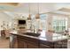 Kitchen island featuring a granite countertop with pendant lights, seamlessly blending with the open-concept living space at 15103 Honeycutt Dr, Huntersville, NC 28078