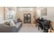 Bright living room with sofa, piano, decorative glass display cabinet and neutral colored walls at 15103 Honeycutt Dr, Huntersville, NC 28078