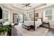 Spacious main bedroom featuring a four-poster bed, sitting area, and large windows for ample natural light at 15103 Honeycutt Dr, Huntersville, NC 28078