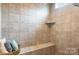 Contemporary tile shower with a built-in bench and niche for storage, offering a relaxing experience at 15103 Honeycutt Dr, Huntersville, NC 28078