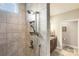Modern tile shower with multiple shower heads and a view into the rest of the beautifully-designed bathroom at 15103 Honeycutt Dr, Huntersville, NC 28078