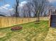 Landscaped backyard featuring a new wood fence, green grass and newly planted trees at 1516 N Caldwell St, Charlotte, NC 28206