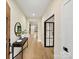 Elegant entryway featuring hardwood floors, neutral walls, stylish console table, and modern black-framed glass door at 1516 N Caldwell St, Charlotte, NC 28206