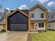 Striking modern farmhouse exterior featuring a two-car garage, contrasting siding and bright trim details at 1516 N Caldwell St, Charlotte, NC 28206