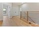 Hallway features hardwood floors, modern railings, closet, and doorway to adjacent rooms at 1516 N Caldwell St, Charlotte, NC 28206