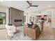 Open-concept living room with hardwood floors, a fireplace, a ceiling fan, and seamless flow into the dining area at 1516 N Caldwell St, Charlotte, NC 28206