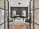 Inviting home office with patterned wallpaper, two windows, an area rug, and black framed glass doors at 1516 N Caldwell St, Charlotte, NC 28206