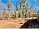 Wooded backyard featuring a wood playset, mature trees, and partial fencing at 177 Highland Woods Ct, Denver, NC 28037
