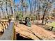 Wooded backyard featuring a playset with slide and swing, partially enclosed by a rustic wooden fence at 177 Highland Woods Ct, Denver, NC 28037