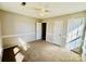 A carpeted bedroom features neutral walls, a ceiling fan, and a window letting in natural light at 177 Highland Woods Ct, Denver, NC 28037