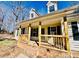 Detailed view of the covered front porch with brick base and wood railings at 177 Highland Woods Ct, Denver, NC 28037