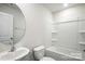 This bathroom has a white vanity, oval mirror, and a shower and tub combination with built in shelves at 225 Kennerly Ave # A, Mooresville, NC 28115