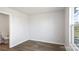 Empty bedroom with hardwood floors, a window providing natural light, and a connecting bathroom at 225 Kennerly Ave # A, Mooresville, NC 28115