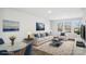 Bright, staged living room featuring neutral furniture, blue accents, and plenty of natural light from the large windows at 225 Kennerly Ave # A, Mooresville, NC 28115