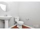 Cozy half-bathroom with pedestal sink and hardwood style floor at 2313 Calabassas Ln, Matthews, NC 28105