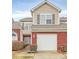 Two-story home featuring a red brick and tan siding facade with an attached two-car garage at 2313 Calabassas Ln, Matthews, NC 28105