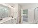 Modern bathroom with double vanity, marble floors, glass shower and an open doorway to bedroom at 237 Miramar Dr, York, SC 29745