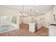 An open kitchen featuring sleek white cabinetry, a spacious island, and stainless steel appliances, complemented by hardwood floors at 237 Miramar Dr, York, SC 29745