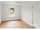 Bedroom featuring hardwood floors, white walls, and a window with backyard view at 2425 Ellen Ave, Charlotte, NC 28208
