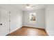 Bright bedroom with hardwood floors, white walls, ceiling fan, and a window providing natural light at 2429 Ellen Ave, Charlotte, NC 28208
