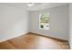 Bedroom featuring hardwood floors, white walls, and a large window with natural light at 2429 Ellen Ave, Charlotte, NC 28208